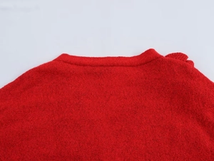 Nahaufnahme des V-Ausschnitts und der feinen Strickstruktur dieser roten Strickjacke