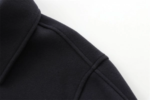 Close-up of deep blue wool coat shoulder showing premium felt texture and stitching