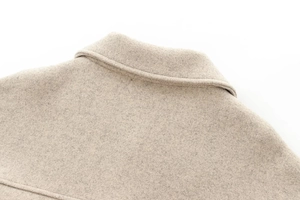 Detail of oatmeal wool blend notched lapel with premium textured felt fabric stitching