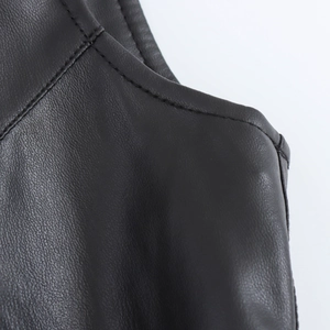 Detailaufnahme der feinen Nähte und Textur des schwarzen Lederkleides in Nahaufnahme