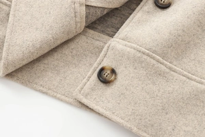 Detailed macro view of beige wool blend fabric texture with dark marble resin buttons