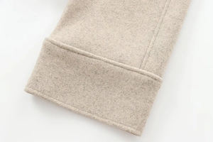 Close-up of beige felt coat detail showing high-quality stitching and fabric texture