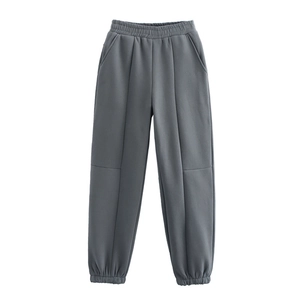 Dettaglio dei pantaloni jogger grigi con vita elastica e cucitura frontale netta