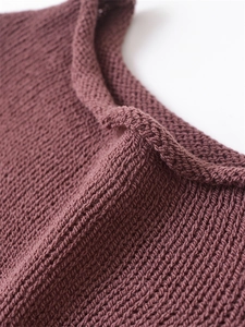 Detailed macro view of deep purple knit sweater showing round rolled neckline and texture