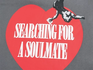 Dettaglio felpa grigia lavata con cuore rosso e stampa Searching For A Soulmate qui