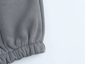 Dettaglio del polsino elastico a costine grigio scuro sulla felpa in cotone lavato