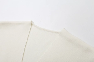 Dettaglio dello scollo a V e trama a maglia sulla camicia beige a maniche corte in tessuto