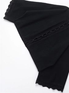 Close-up of black knit cardigan featuring elegant lace trim and delicate bead details