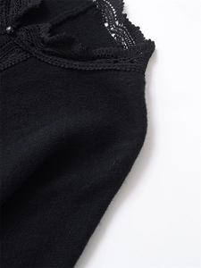 Detailed view of the intricate black lace patchwork and knit texture on the collar