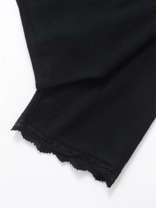 Detailed macro view of black knit sweater featuring elegant lace trim and ribbed cuff edges