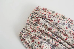 Dettaglio della vita elastica su un abito elegante a maniche lunghe con motivi paisley