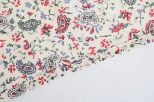 Dettaglio della stampa floreale e paisley sul tessuto dell'abito a maniche lunghe