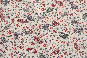 Dettaglio macro del motivo paisley su tessuto crema per abito floreale a maniche lunghe