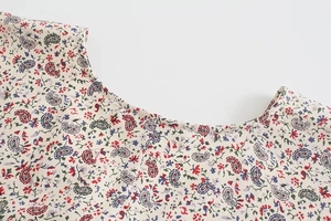 Dettaglio del motivo floreale paisley sulla scollatura di questo elegante abito a maniche lunghe