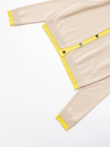Détail des poignets côtelés jaunes contrastés et de l'ourlet du cardigan beige
