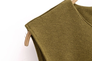 Close-up of olive green ribbed knit fabric showing detailed stitching on the shoulder seam