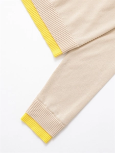 Détail du cardigan en maille beige et jaune avec texture de poignet en côtes doublées