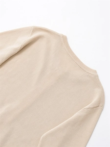 Détail du col rond et de la texture en maille fine sur ce cardigan beige uni