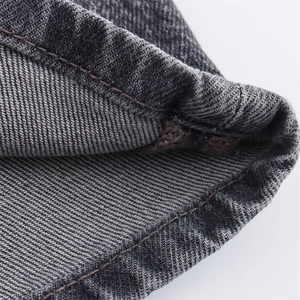 Detalle de mezclilla gris oscuro con costuras reforzadas y textura de sarga de la prenda
