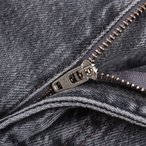 Primer plano de la cremallera metálica YKK en pantalones cortos vaqueros gris carbón