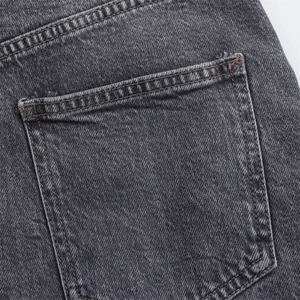 Primer plano detallado del bolsillo trasero en denim gris oscuro con costuras finas