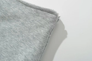 Détail de la texture en tricot gris avec fermeture éclair blanche et couture fine