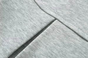 Gros plan détaillé sur un tissu en maille gris clair avec couture à double aiguille