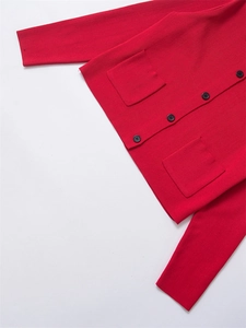 Détail d'un cardigan en tricot rouge avec boutons noirs et poches avant plaquées