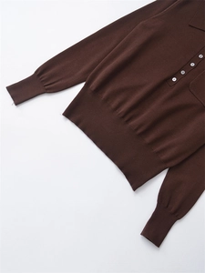 Detailaufnahme von Rippbündchen und Saum eines dunkelbraunen Polostrickpullovers