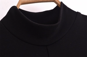Close-up of black mock neck knitted dress with ribbed texture on a wooden hanger