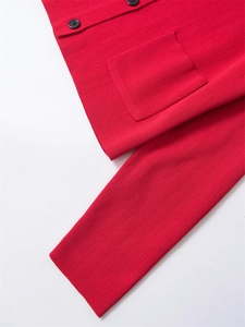 Gros plan du cardigan en tricot rouge avec boutons noirs et détail de poche carrée