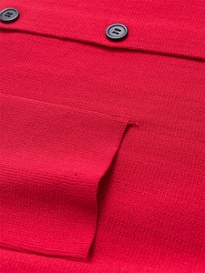 Gros plan sur la texture d'un gilet rouge en maille avec poches et boutons noirs