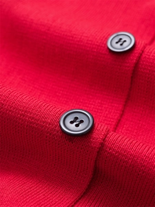 Gros plan de boutons noirs sur une maille rouge vif avec texture côtelée douce