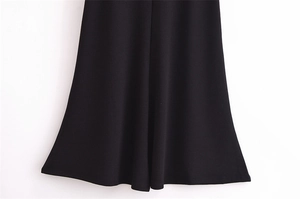 Close-up of black knitted hemline showing fine fabric texture and premium drape