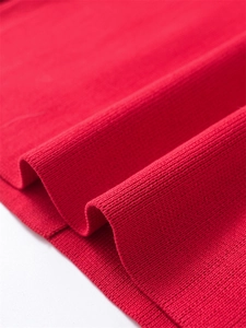 Vue macro de la texture en maille côtelée rouge vif montrant la douceur du tissu