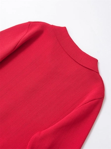 Détail d'un pull en maille rouge à col montant montrant la texture côtelée et la couture