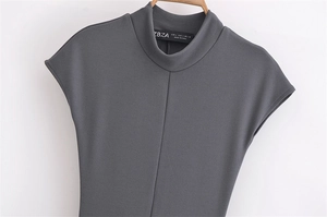 Close-up detail of dark gray high neck knitted dress with brand label and size tag