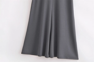 Detailed macro view of the wide flowing hem on a charcoal gray sleeveless dress