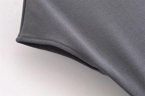 Detailed macro view showing the soft knitted texture and flat seams of the dark grey dress
