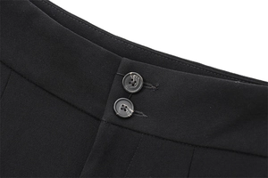 Gros plan du pantalon noir drapé avec taille à double boutonnage et effet marbré
