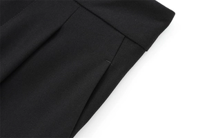 Détails de la taille plissée et des poches latérales sur un pantalon large noir