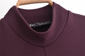 Close-up of mock neck knit dress with detailed burgundy fabric texture and brand tag