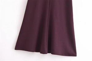 Close-up of deep purple dress fabric showing fine stitching and smooth draped hemline
