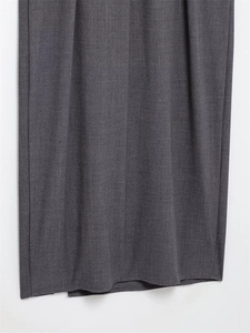 Vue détaillée de la texture du tissu tissé gris foncé avec un drapé élégant sur la robe