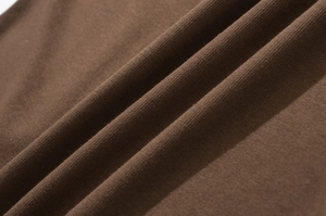 Vue macro de la texture du tissu tricoté marron foncé avec drapés et détails de fibres