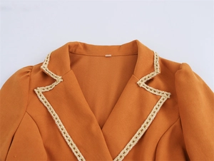 Detail of ginger orange blazer dress neckline with elegant lace trim and textured fabric