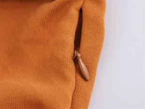 Close-up of invisible drop-shaped zipper and mustard yellow knit fabric detail