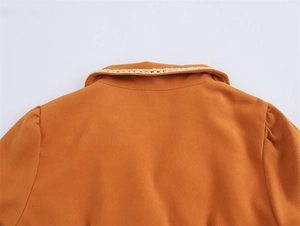 Detailed close-up of French-style orange dress neckline with elegant lace trim and pleats