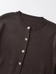 Dettaglio del girocollo e dei bottoni effetto marmo su un cardigan in maglia marrone