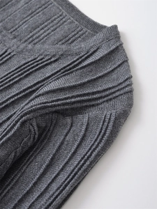 Detailed macro view of light gray knit top showing vertical ribbed texture and craftsmanship